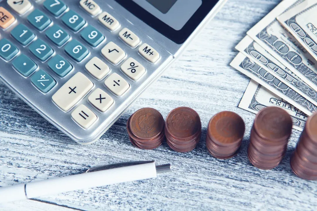 calculator and money on a table with a city skyline in the background