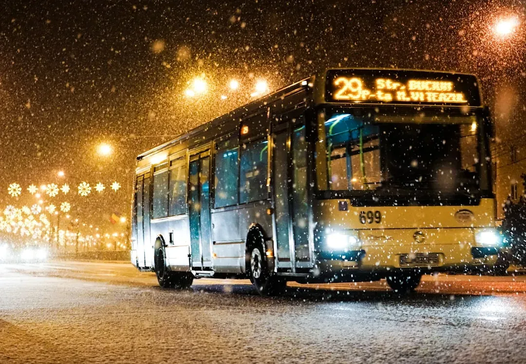 a city bus driving through a city at night with neon lights